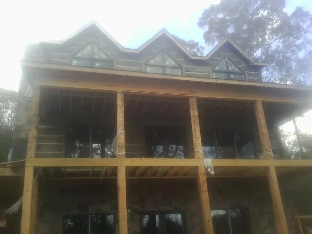 Dormers and porch framing on a large log home under construction — Roof Coating work by our crew in Montchanin