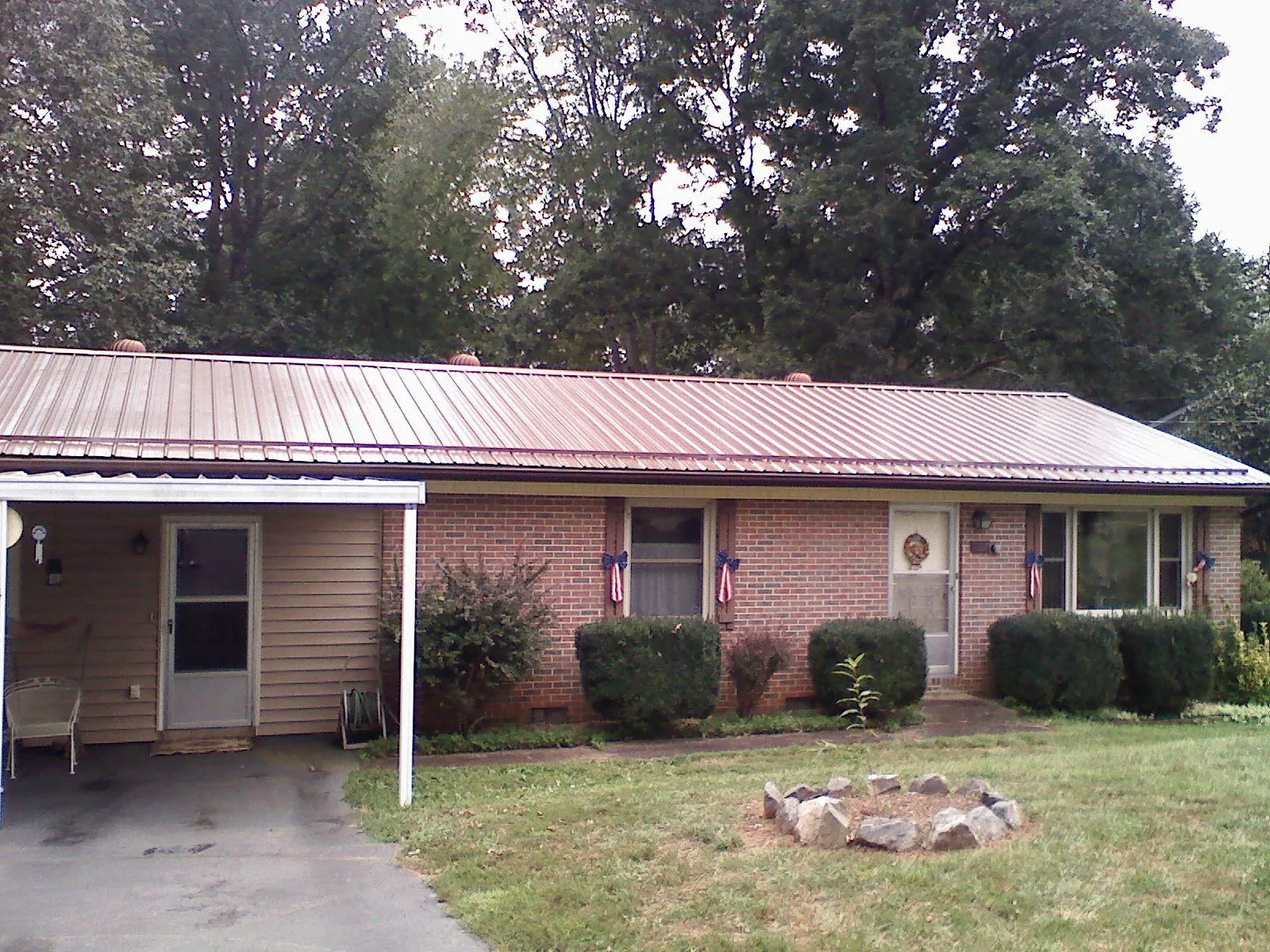 Bronze metal roof and carport on a brick ranch home — Roof Repair work by our crew in Montchanin